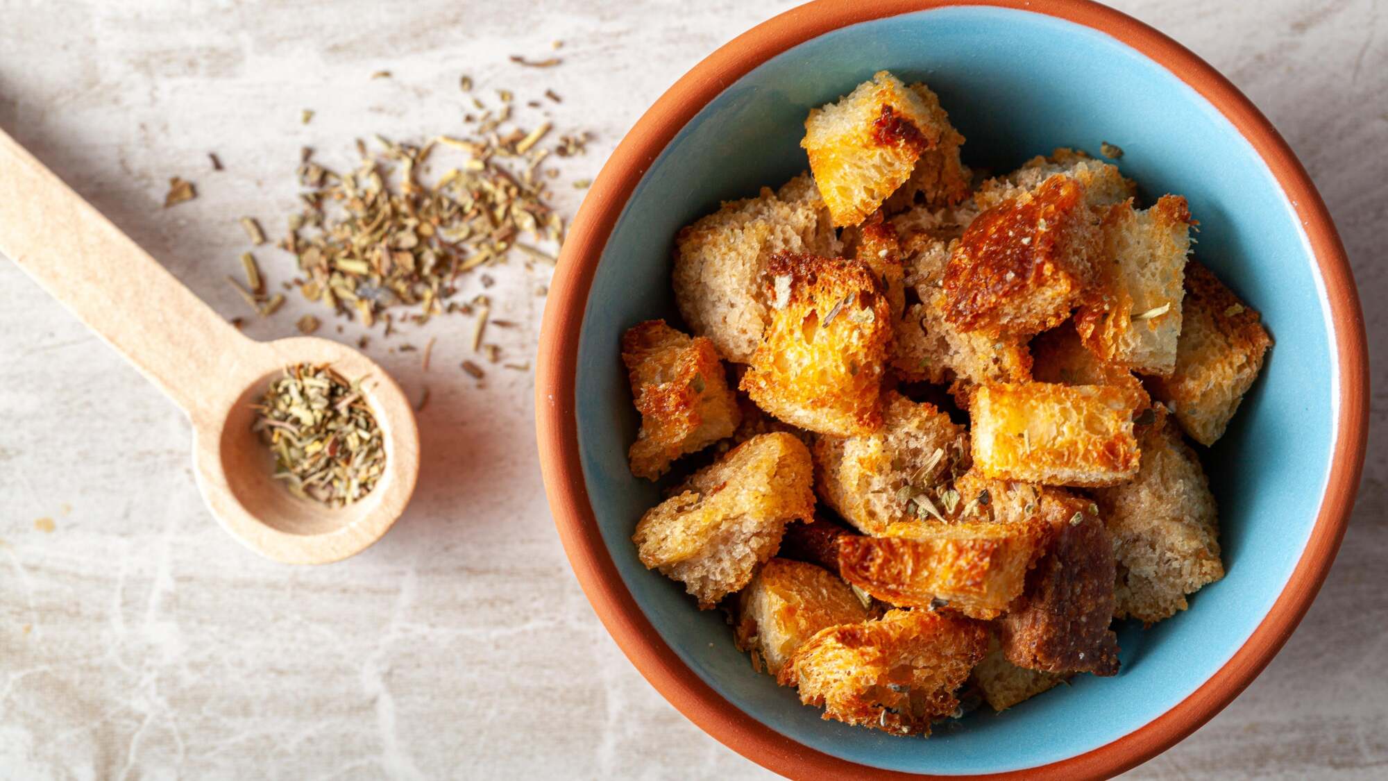 A bowl of croutons on a table.