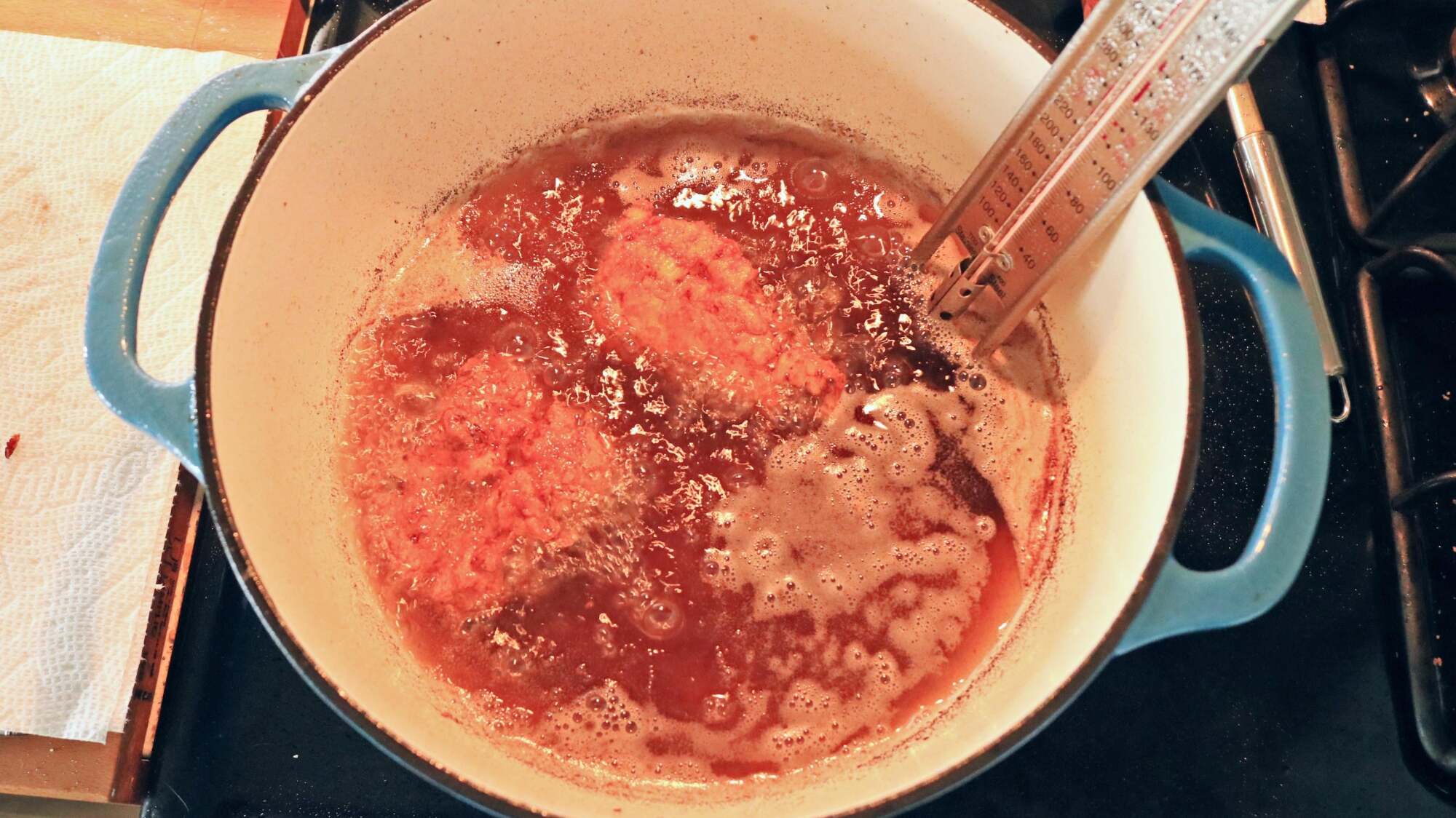 Chicken frying in a large pot.