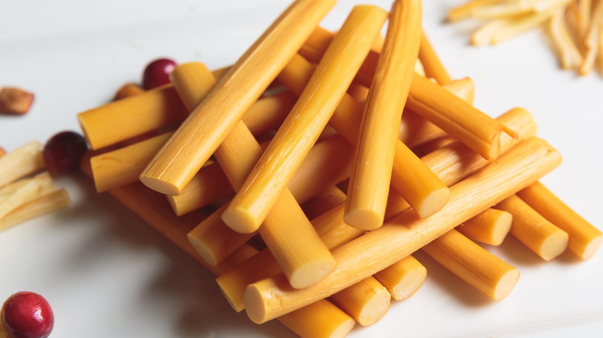 Smoked cheese sticks on a white plate.