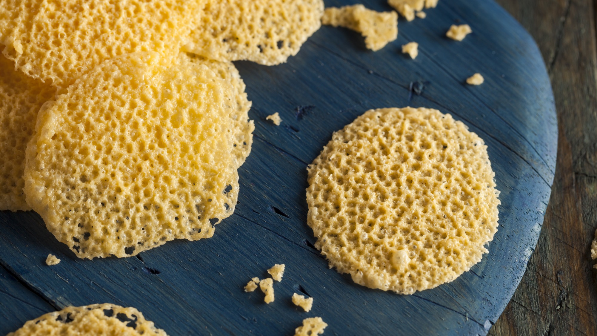 Parmesan cheese crisps on a slate board.