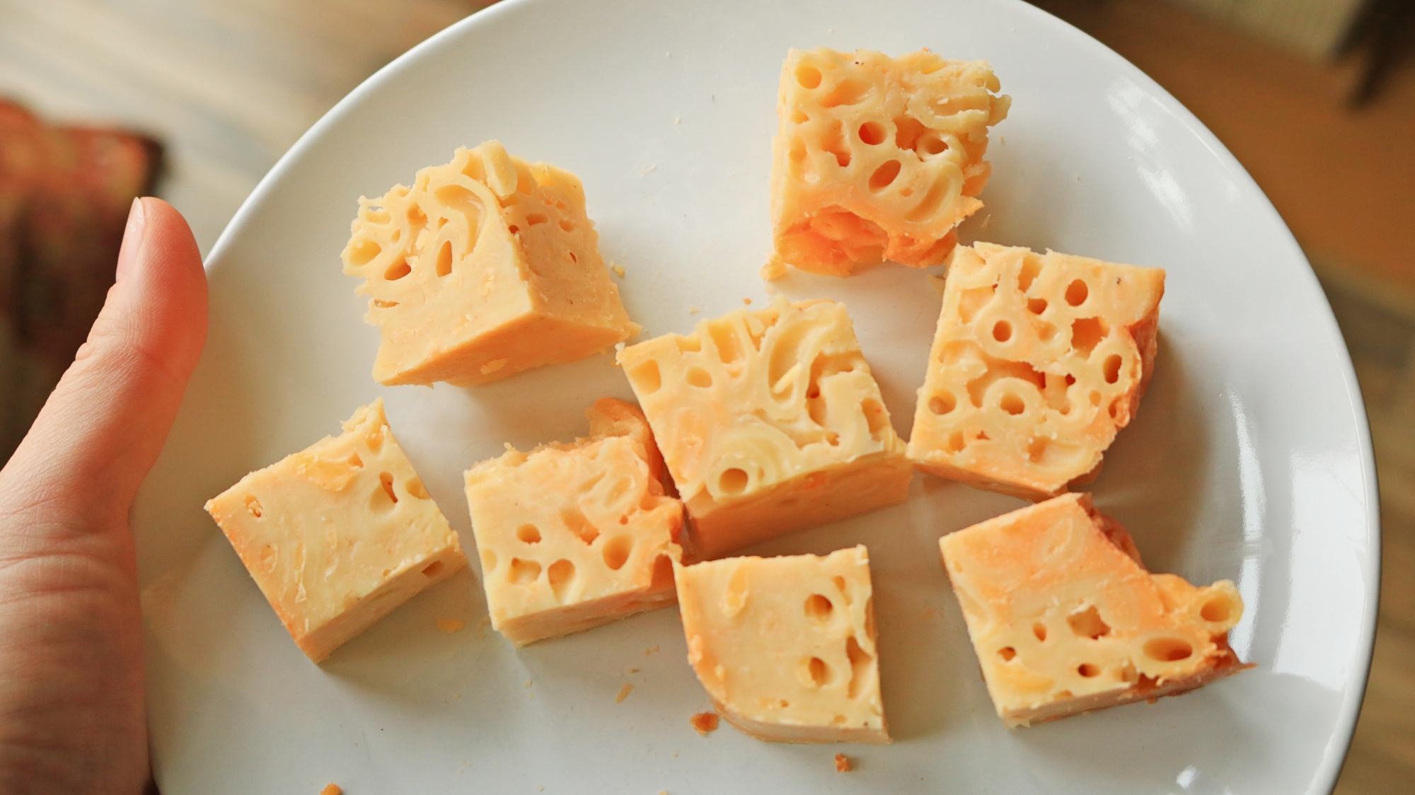 Squares of chopped mac and cheese on a plate.