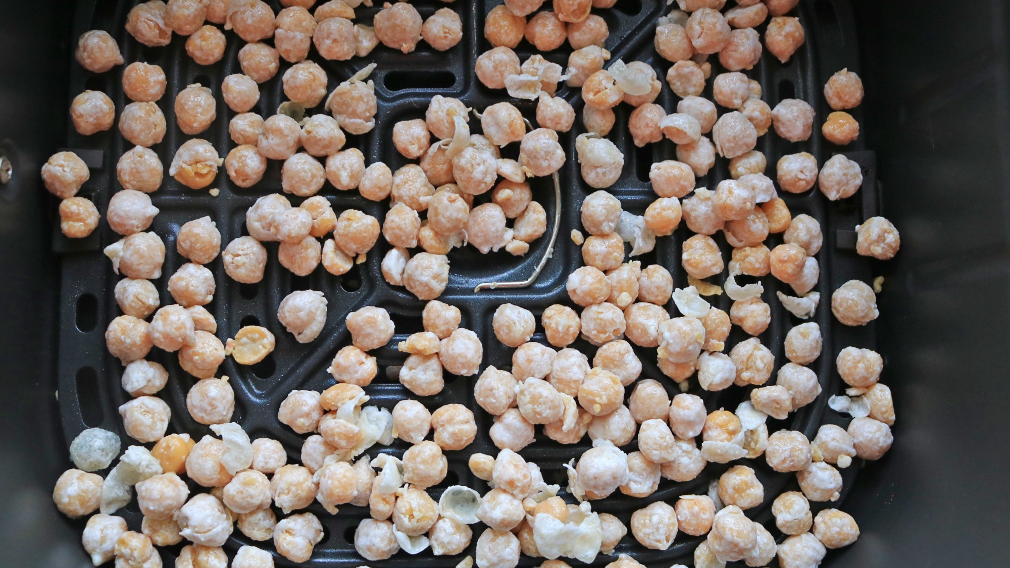 Chickpeas in an air fryer basket.