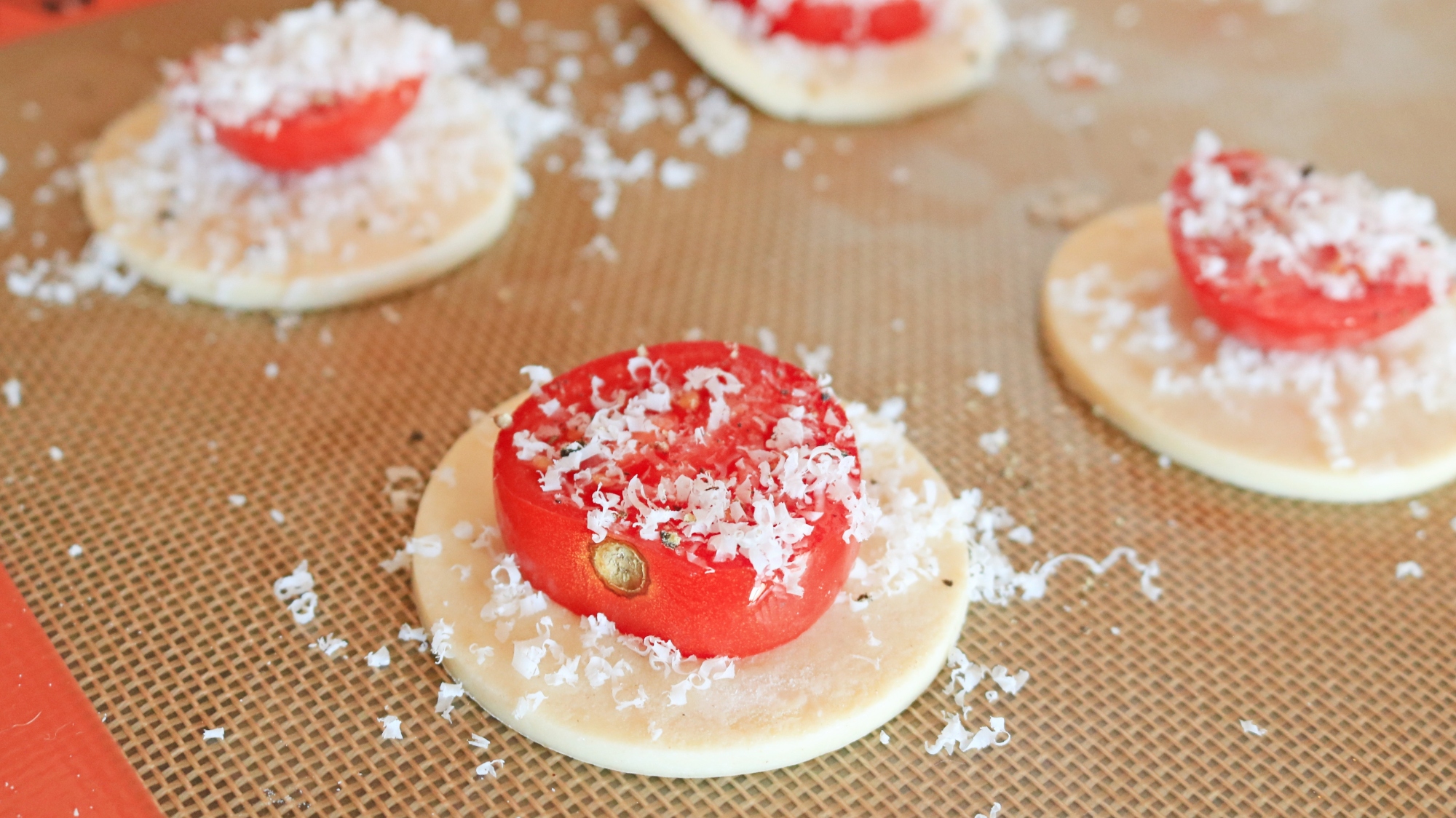 Raw tomato slices on top of unbaked pastry circles.