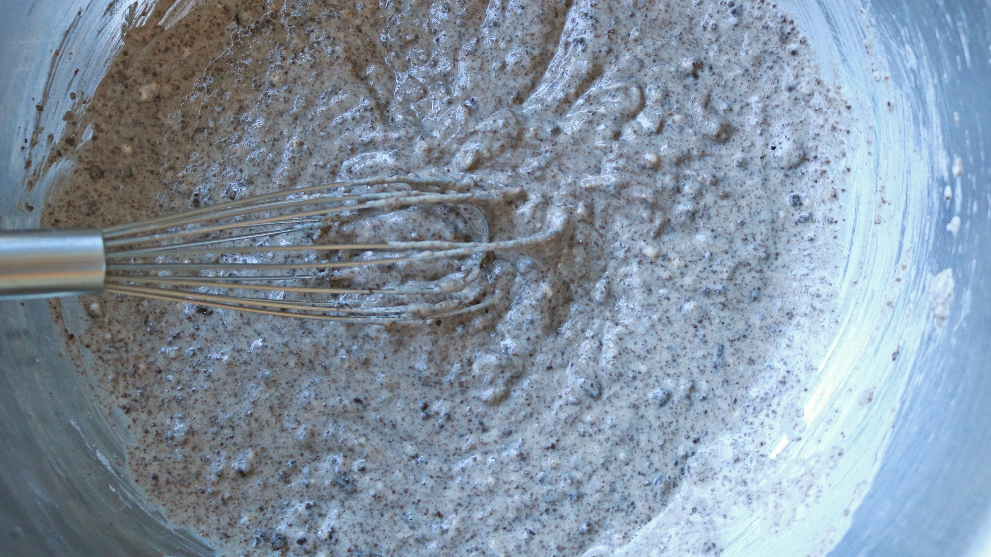 Pancake batter in a bowl with a whisk.