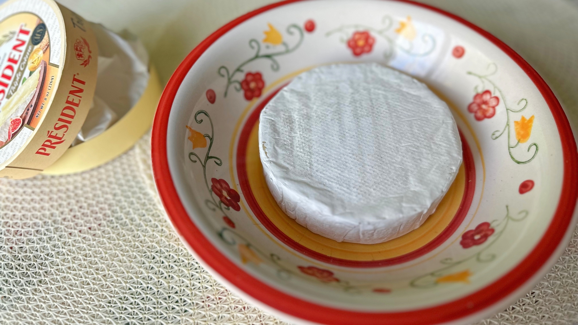 Wheel of brie in a microwave-safe bowl.