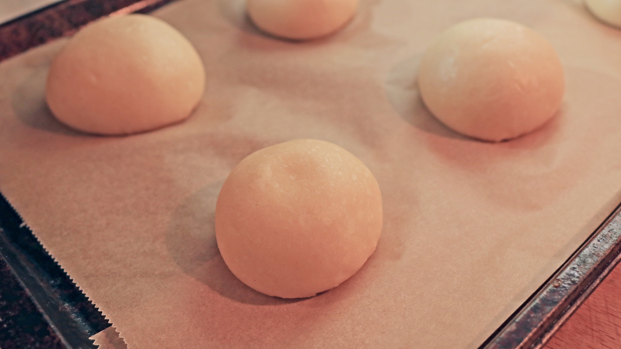 Raw dough balls on a sheet tray.