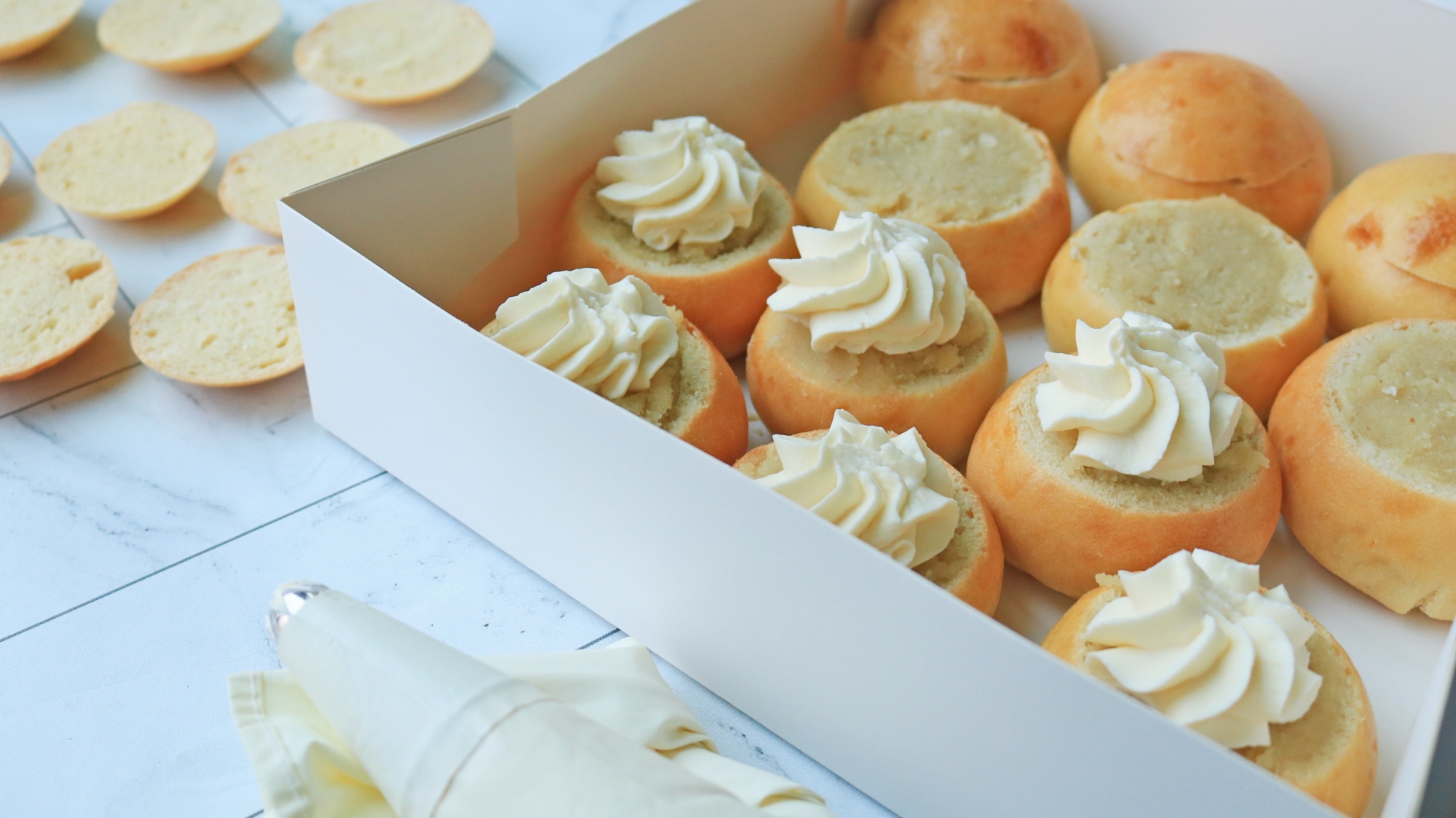 Semlor buns in filling process.