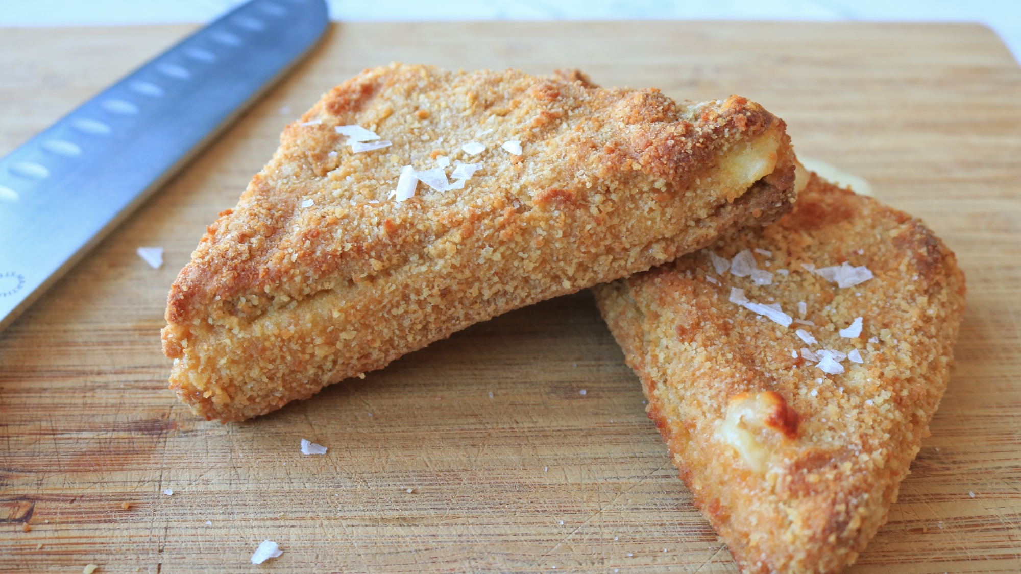 Finished mozzarella in carrozza on a cutting board.