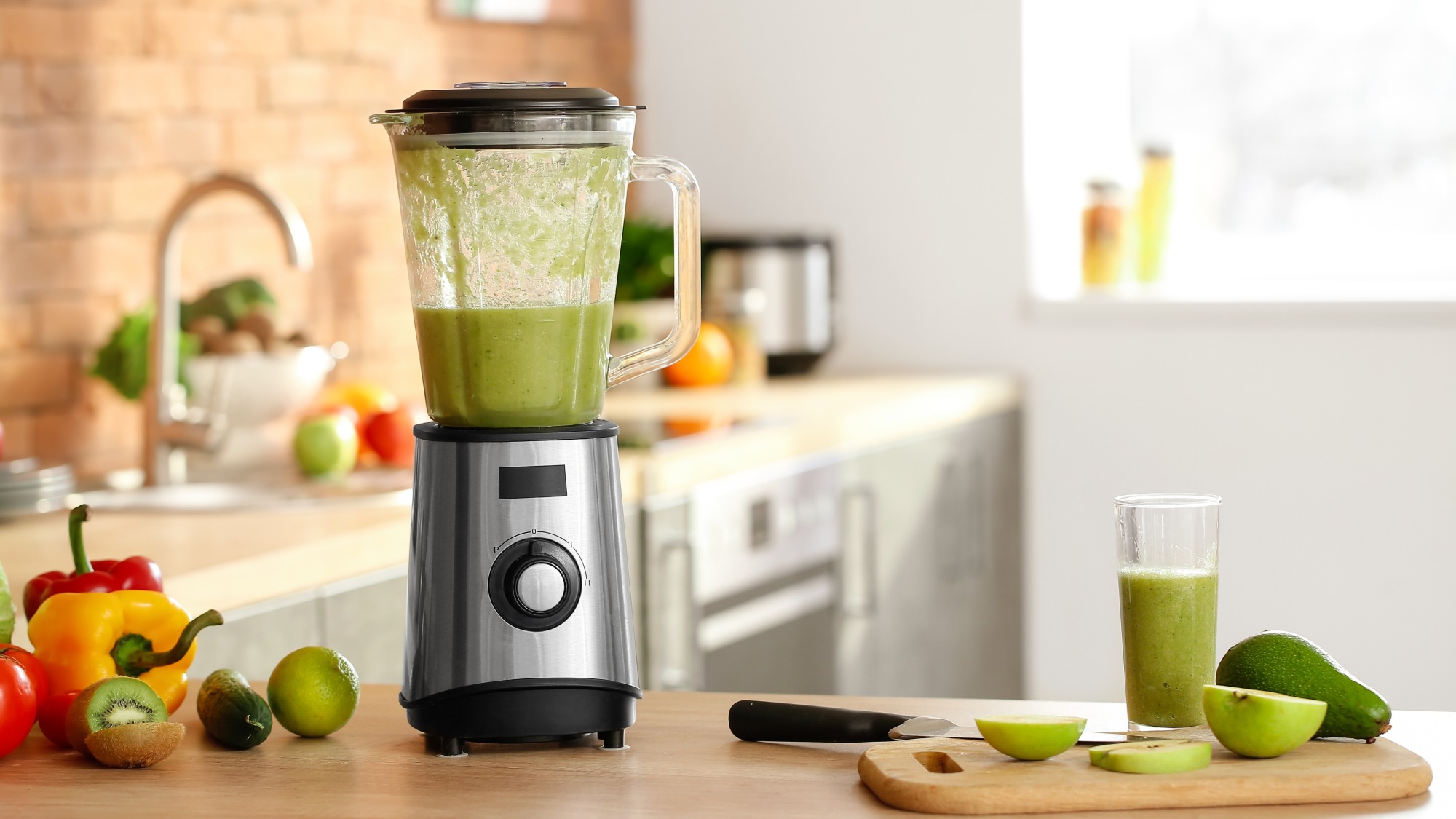 A blender with a green smoothie inside.