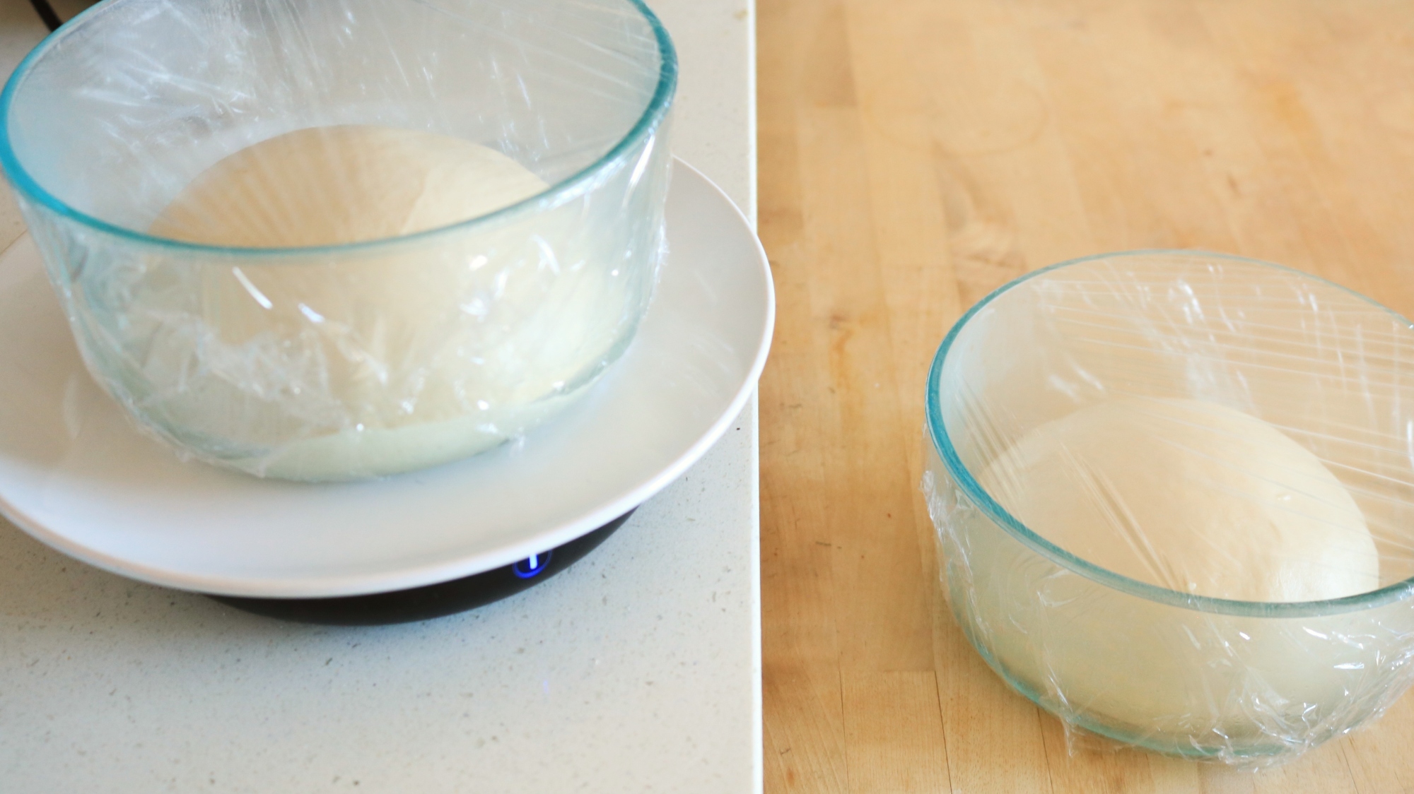 Two bowls with dough inside of them.