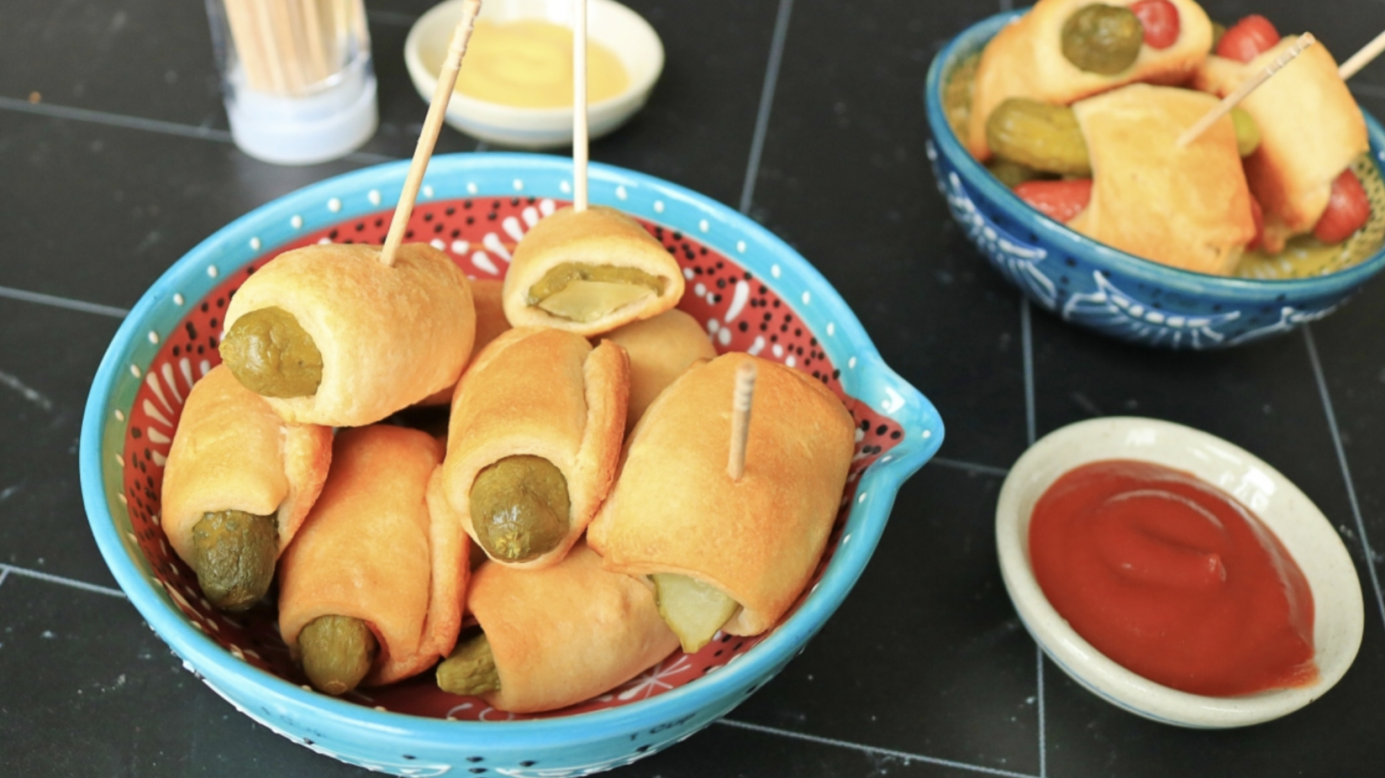 Pickles in a blanket in a small bowl.