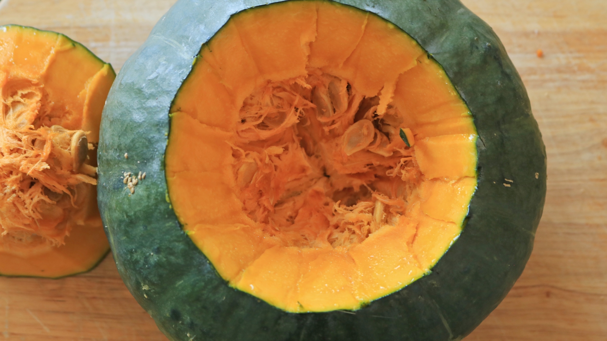 The top cut off of a kabocha squash exposing the inside.