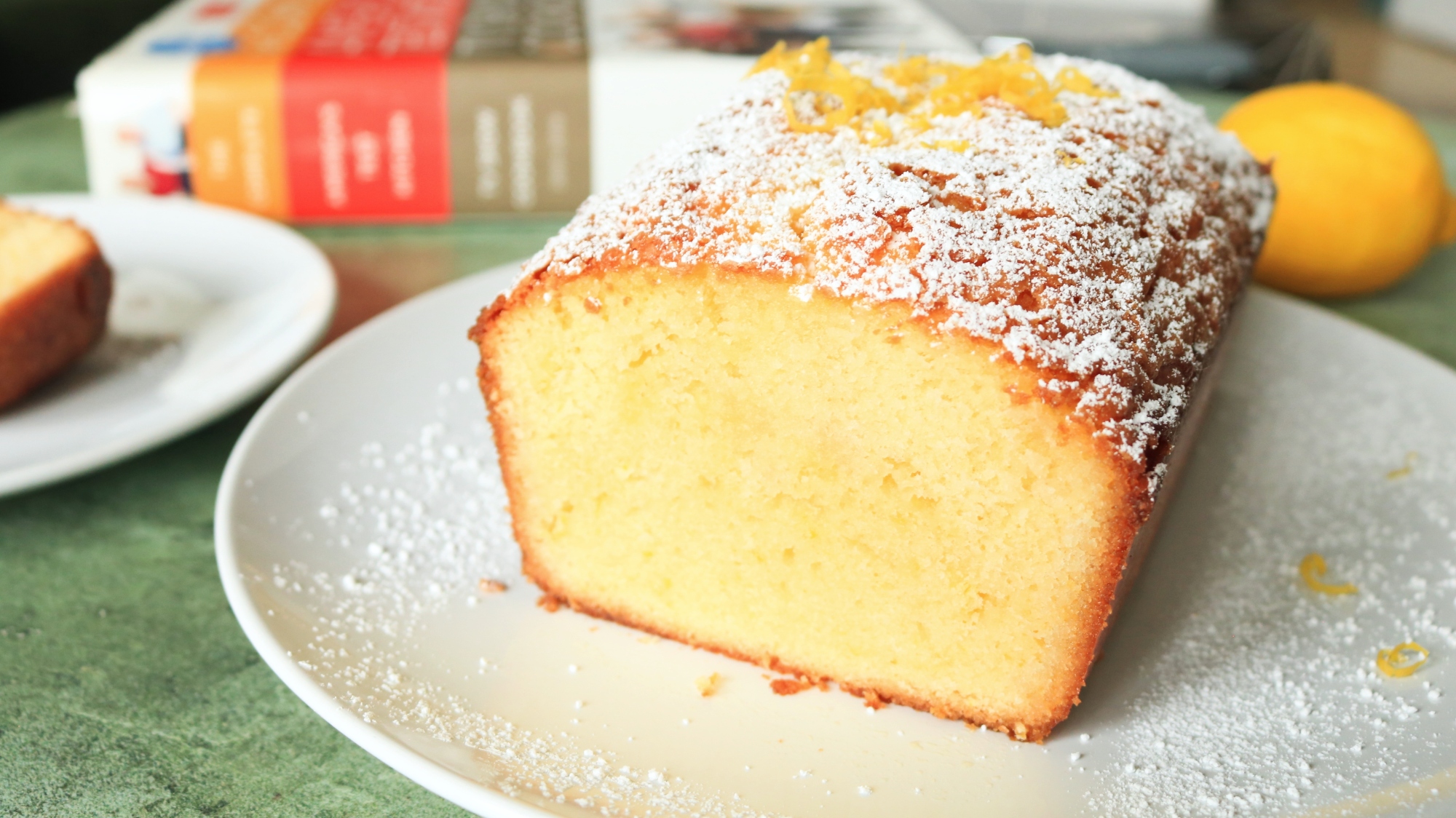 A cut lemon pound cake on a white dish.