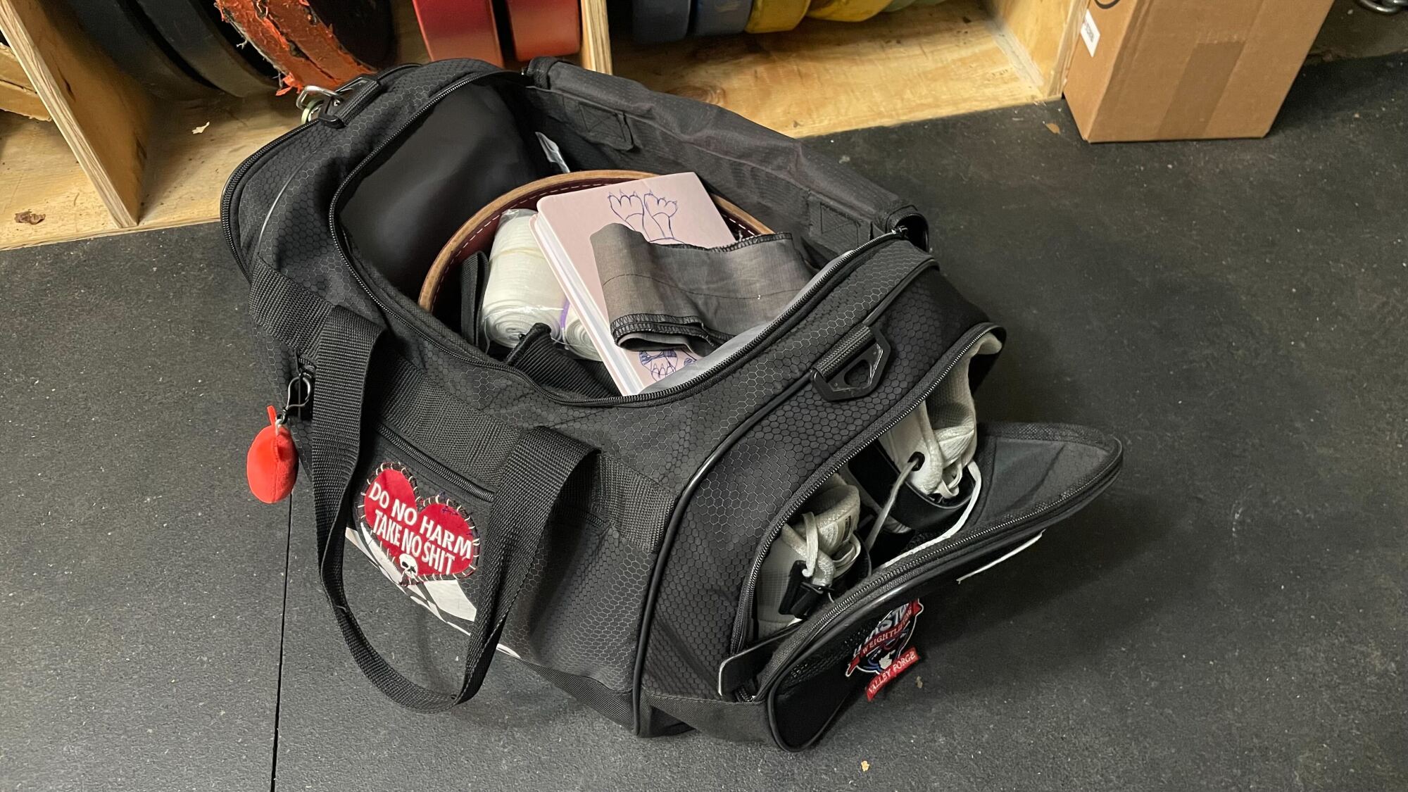 Adidas Defender duffel bag, open, showing belt,training journal, and shoes