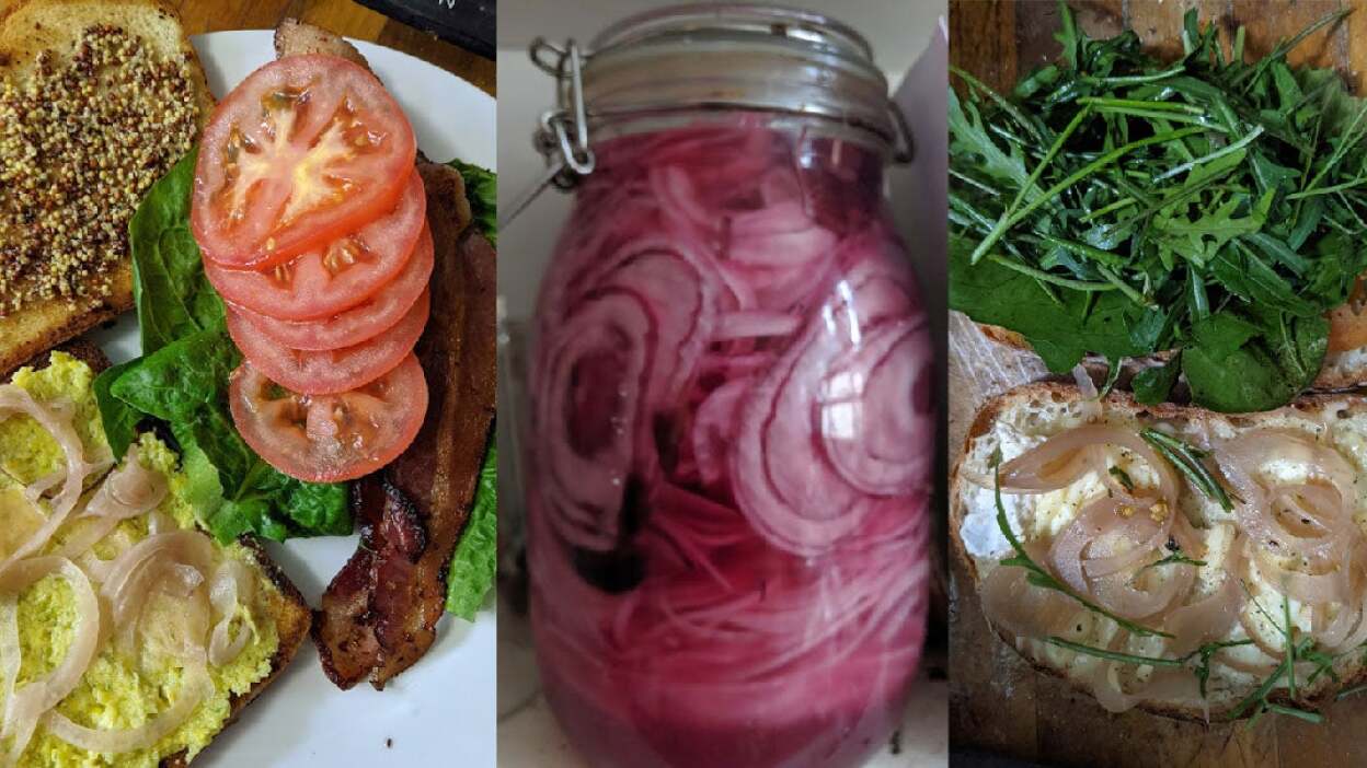 On the left, a tomato sandwich with mustard, smoked corn mayo, tomatoes, lettuce, bacon and pickled onions. On the right, a roast beef sandwich with brie, arugula, radicchio, horseradish and pickled red onions. In the middle, a tall glass jar of pickled red onions. 